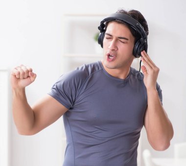 Evde spor yapan ve müzik dinleyen adam.