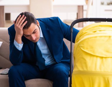 Genç işadamı yeni doğan bebeğe bakıyor.