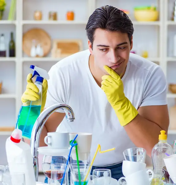 stock image The man frustrated at having to wash dishes