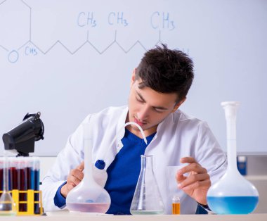 Laboratuvarda oturan genç kimyager.