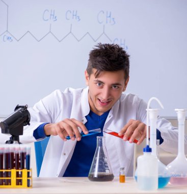 Laboratuvarda oturan genç kimyager.