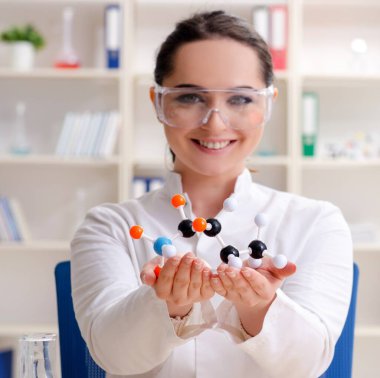 Laboratuvarda çalışan genç kadın kimyager.