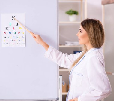 Beyaz tahtanın önünde duran genç bayan doktor.