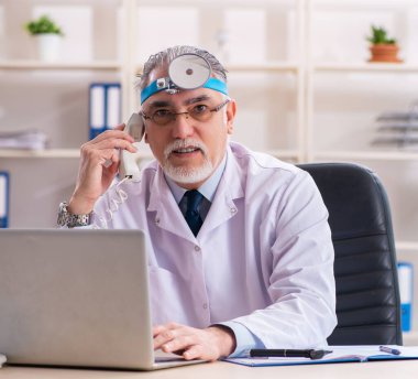 Klinikte çalışan yaşlı erkek laringolog.