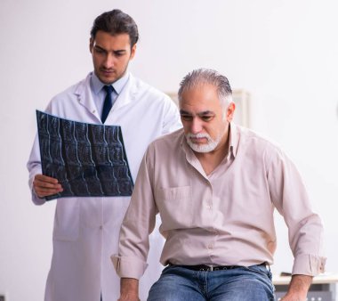 Yaşlı hasta genç doktoru ziyaret ediyor.