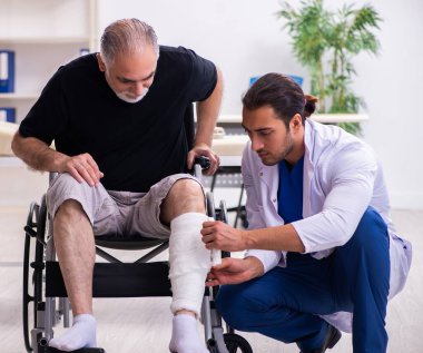 Yaşlı adam genç doktor travmatoloğu ziyaret ediyor.