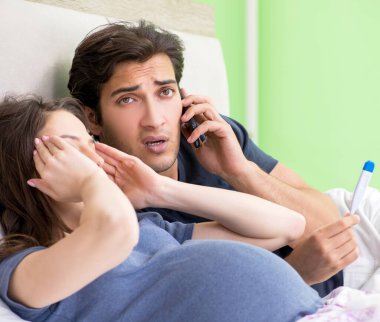 Genç koca hamile karısına bakıyor.