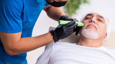 Yaşlı adam estetik ameliyat için doktoru ziyaret ediyor.