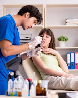 Doktor klinikte tükürük testi örneği alıyor.