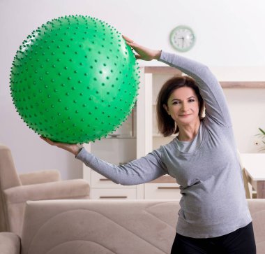 Yaşlı hamile kadın evde egzersiz yapıyor.