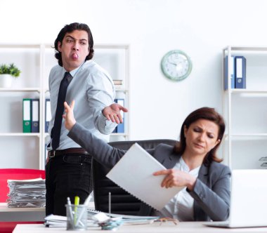 Yaşlı kadın patron ve genç erkek çalışan ofiste.