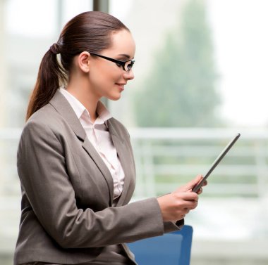 Tablet bilgisayarla çalışan genç iş kadını.