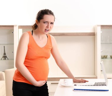 The young pregnant woman working at home clipart