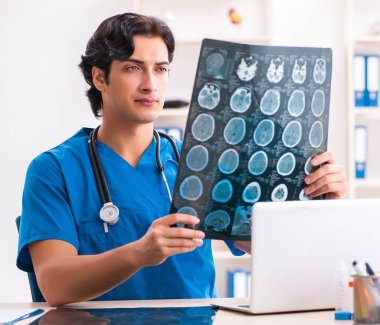 Klinikte çalışan genç erkek radyoloji uzmanı.