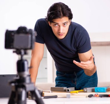 Genç erkek tamirci blogu için video kaydediyor.