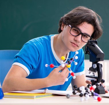 Sınıftaki genç erkek öğrenci.