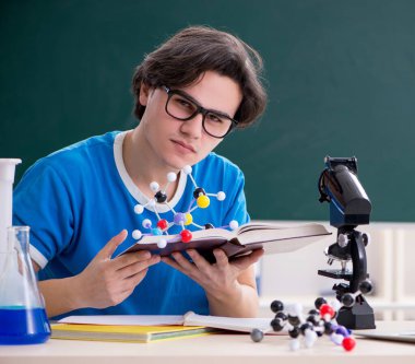 Sınıftaki genç erkek öğrenci.