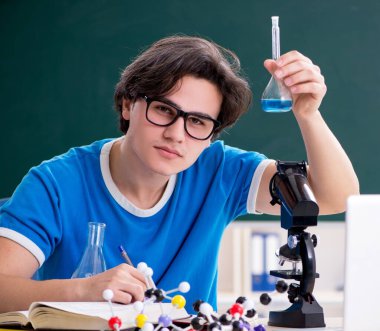 Sınıftaki genç erkek öğrenci.