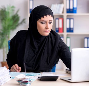 Ofiste çalışan tesettürlü kadın muhasebeci.
