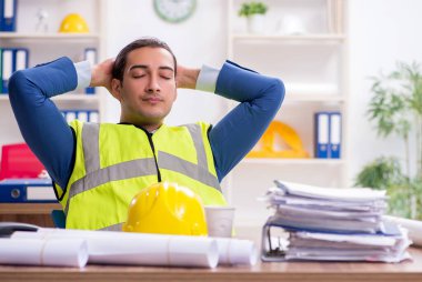 Genç erkek mimar ofiste çalışıyor.