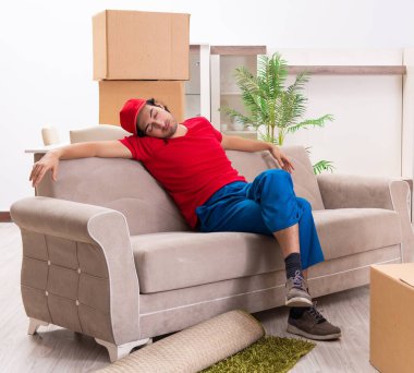 İçeride çalışan kutularla çalışan genç bir erkek müteahhit.