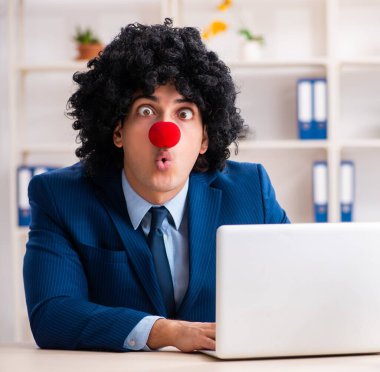 Ofiste çalışan genç palyaço işadamı.