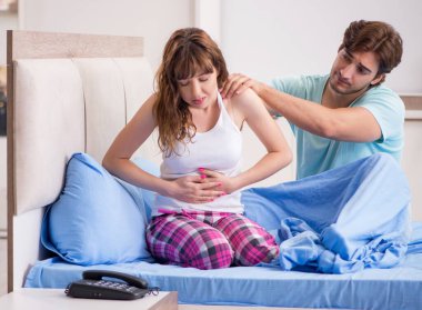 Yatak odasında kocası olan hasta genç kadın.