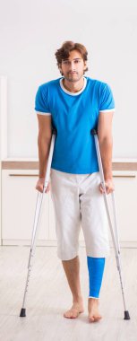 Bacağı yaralı genç adam evde koltuk değnekleriyle