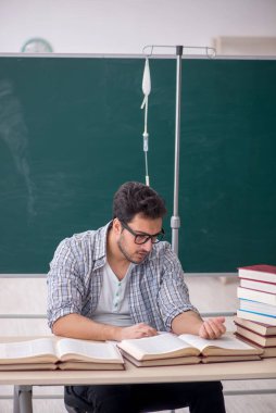 Young teacher suffering in the classroom