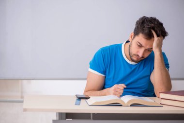 Genç öğrenci beyaz tahtanın önünde.