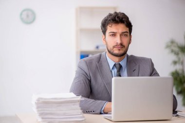 Genç bir çalışan ve ofiste çok fazla iş var.