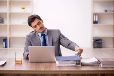 Genç işadamı işyerinde oturuyor.