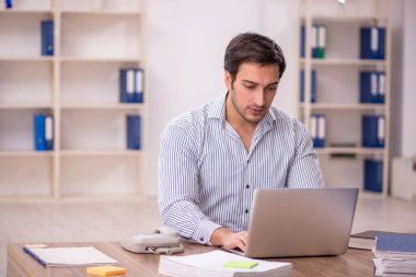 Genç işadamı işyerinde oturuyor.