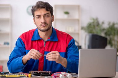 Laboratuvarda bilgisayar tamir eden genç bir tamirci.