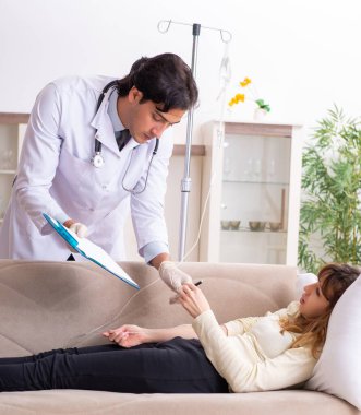 Genç, yakışıklı doktor, kadın hastayı evinde ziyaret ediyor.