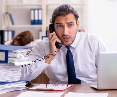 Ofis ortamında çalışan iki çalışan.