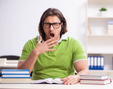 Sınıfta ders çalışan genç bir erkek öğrenci.