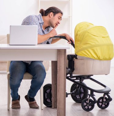 Genç baba evde yeni doğan bebeğe bakıyor.