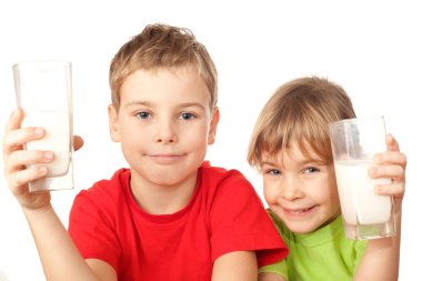 Küçük tatlı kız ve oğlan lezzetli taze süt içerler.