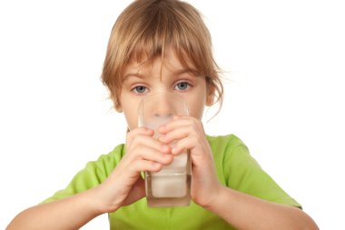 Büyük gözlü, yeşil bluzlu küçük kız lezzetli taze süt içiyor.