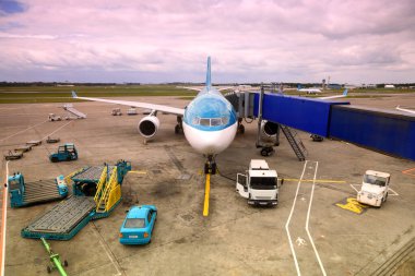 Havaalanına park edilmiş gerçek dışı renkli bir uçak. Yolcu borusu. servis teknisyeni