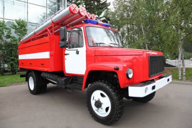 Yaz günü çatıda boruları ve teşhircisi olan büyük kırmızı bir itfaiye arabası.