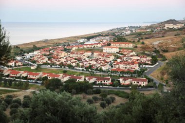 Deniz kıyısında küçük kulübeleri olan tatil köyü panoraması.