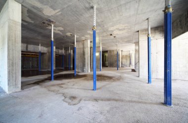Bitmemiş binanın içinde beton tavan için mavi destek