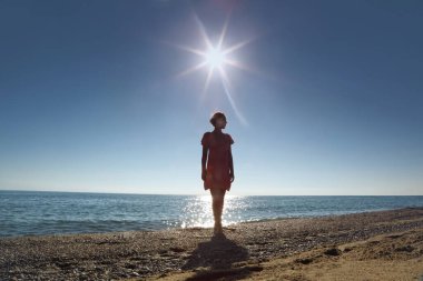 Woman stands ashore  opposite  sun, turn to him  back clipart