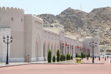 Umman 'daki Sultan' ın Sarayı 'nın duvarına yakın insanlar. Otobüs ve arabalar..