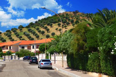 Arabalar kaldırımlara park eder. Yerleşim yerlerinde palmiye ağaçları vardır.