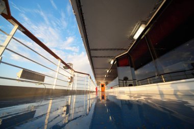 deck of cruise ship in morning shining by light of rising sun. reflection in deck clipart