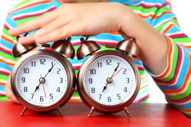 Çizgili tişörtlü çocuğun eli iki alarma basar, alarmlara odaklanır.