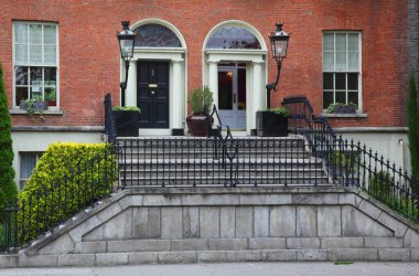 Birinci kat ve kırmızı tuğlalardan oluşan güzel bir binanın girişi.